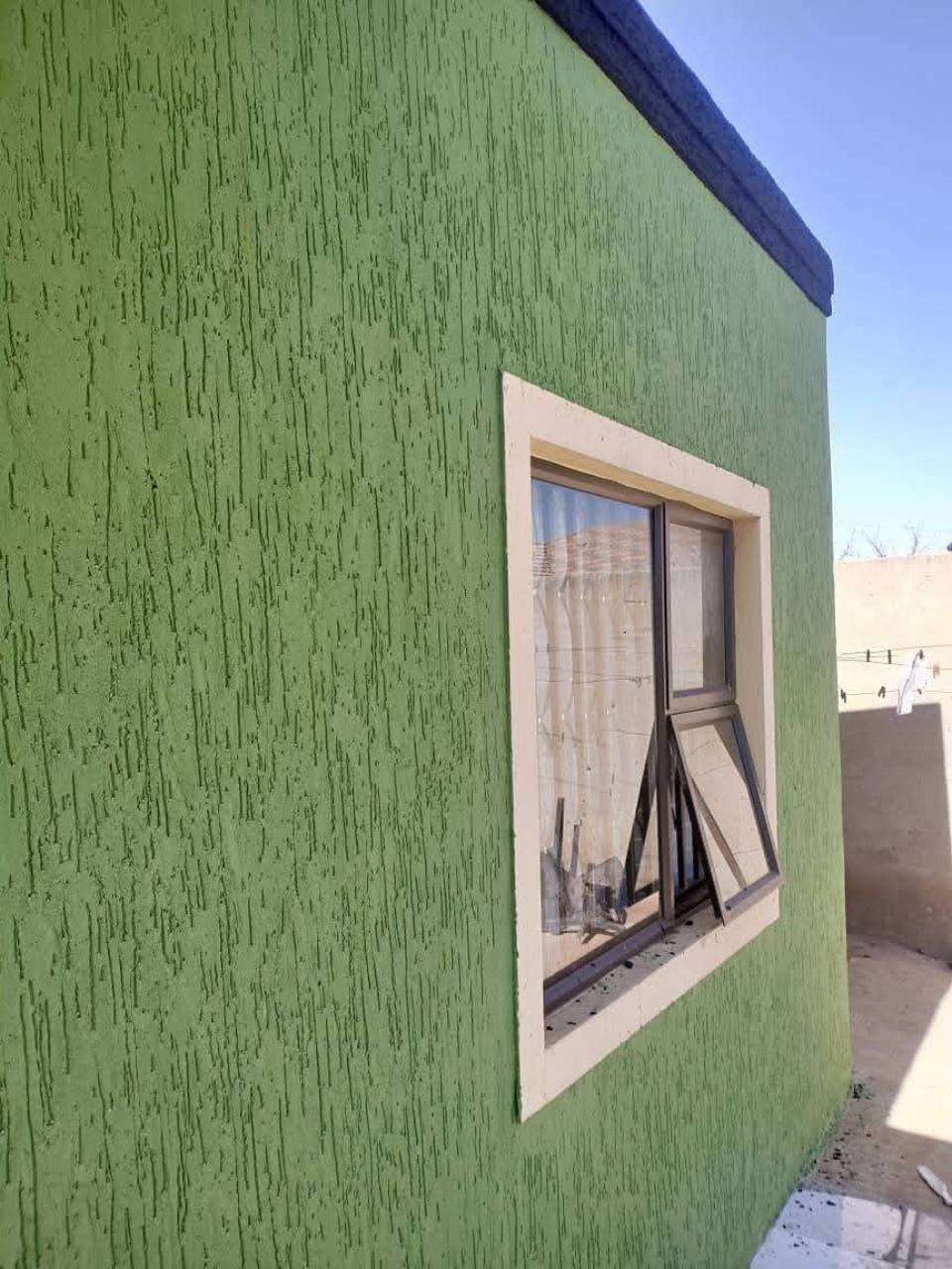 Green Gamazine textured coating around an exterior window