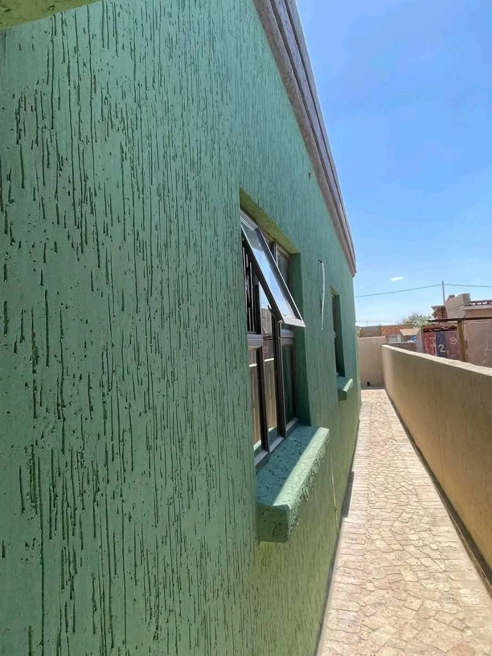 Green Gamazine coating on the exterior side wall of a house
