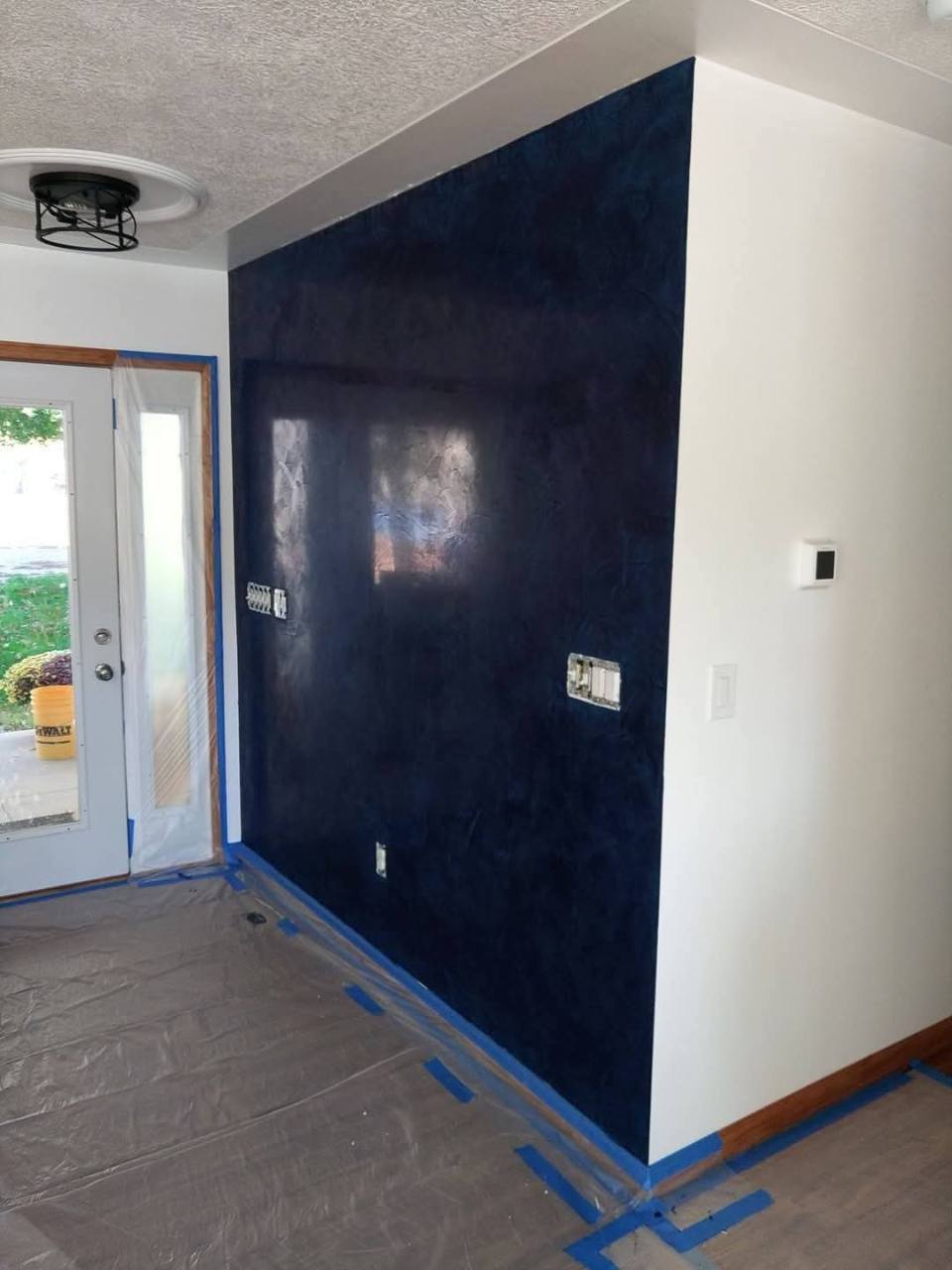 Deep navy decorative feature wall finished by Platinum Home Decor